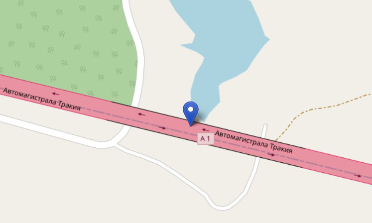 A location pin from OpenStreetMaps on a highway by an artificial lake